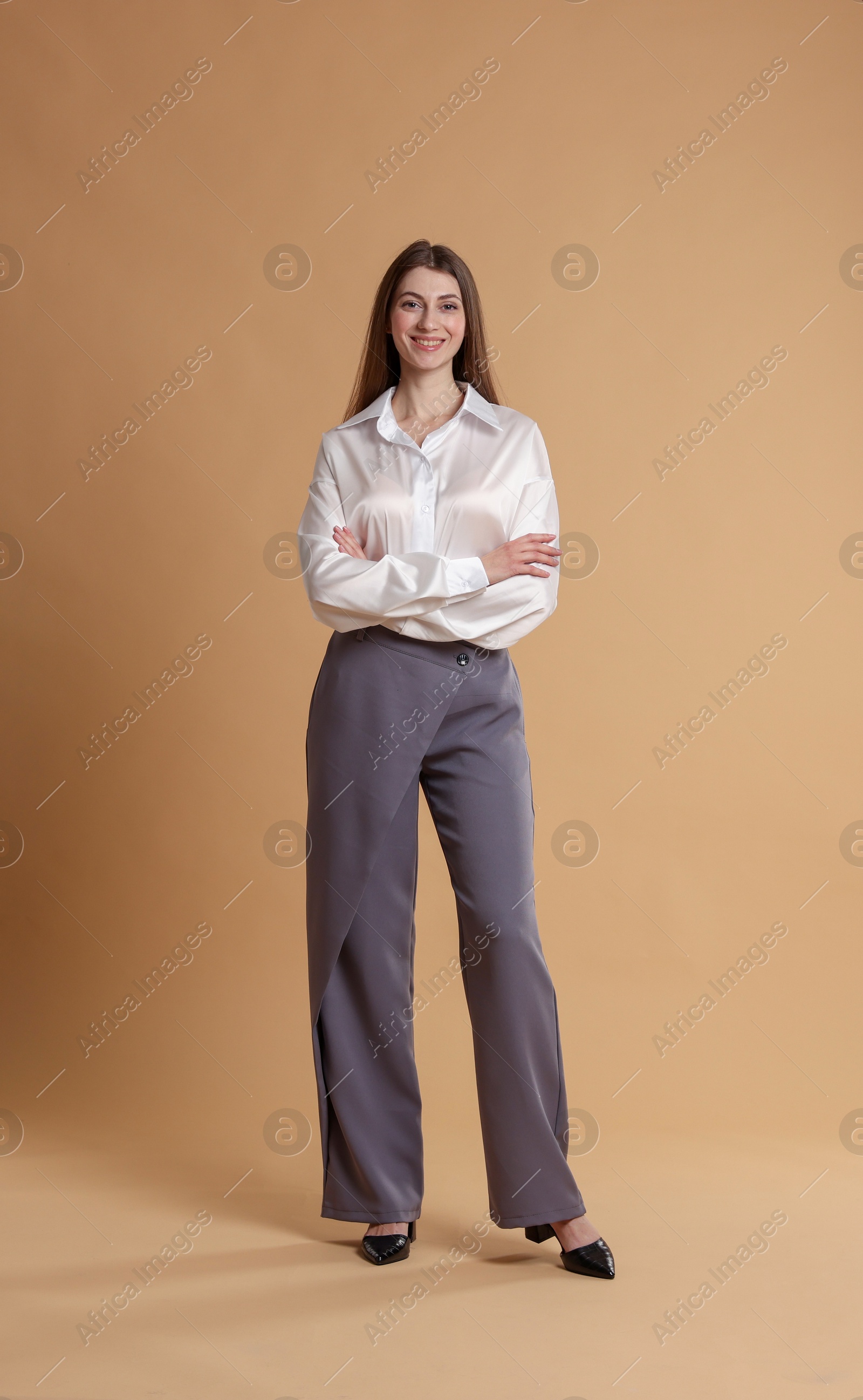 Photo of Beautiful woman in stylish outfit on beige background