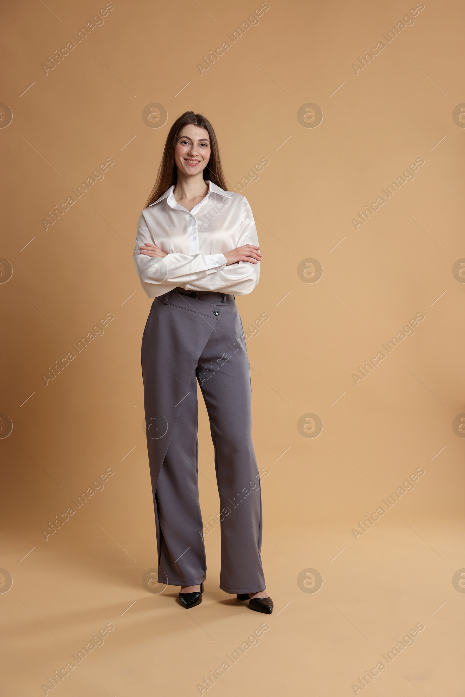 Photo of Beautiful woman in stylish outfit on beige background