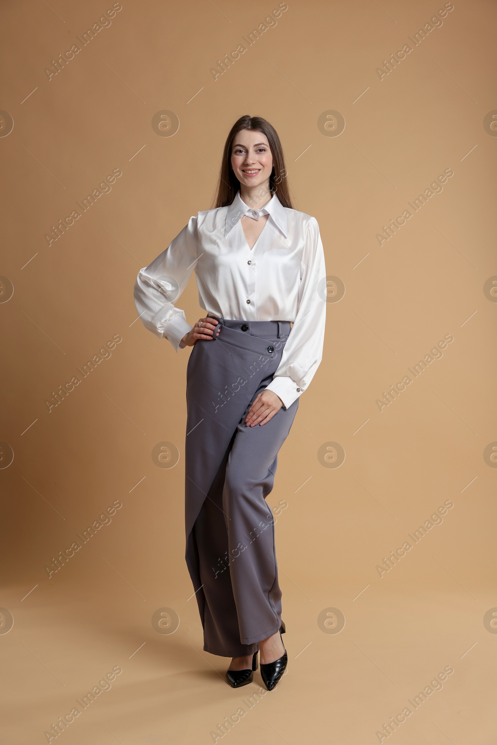 Photo of Beautiful woman in stylish outfit on beige background