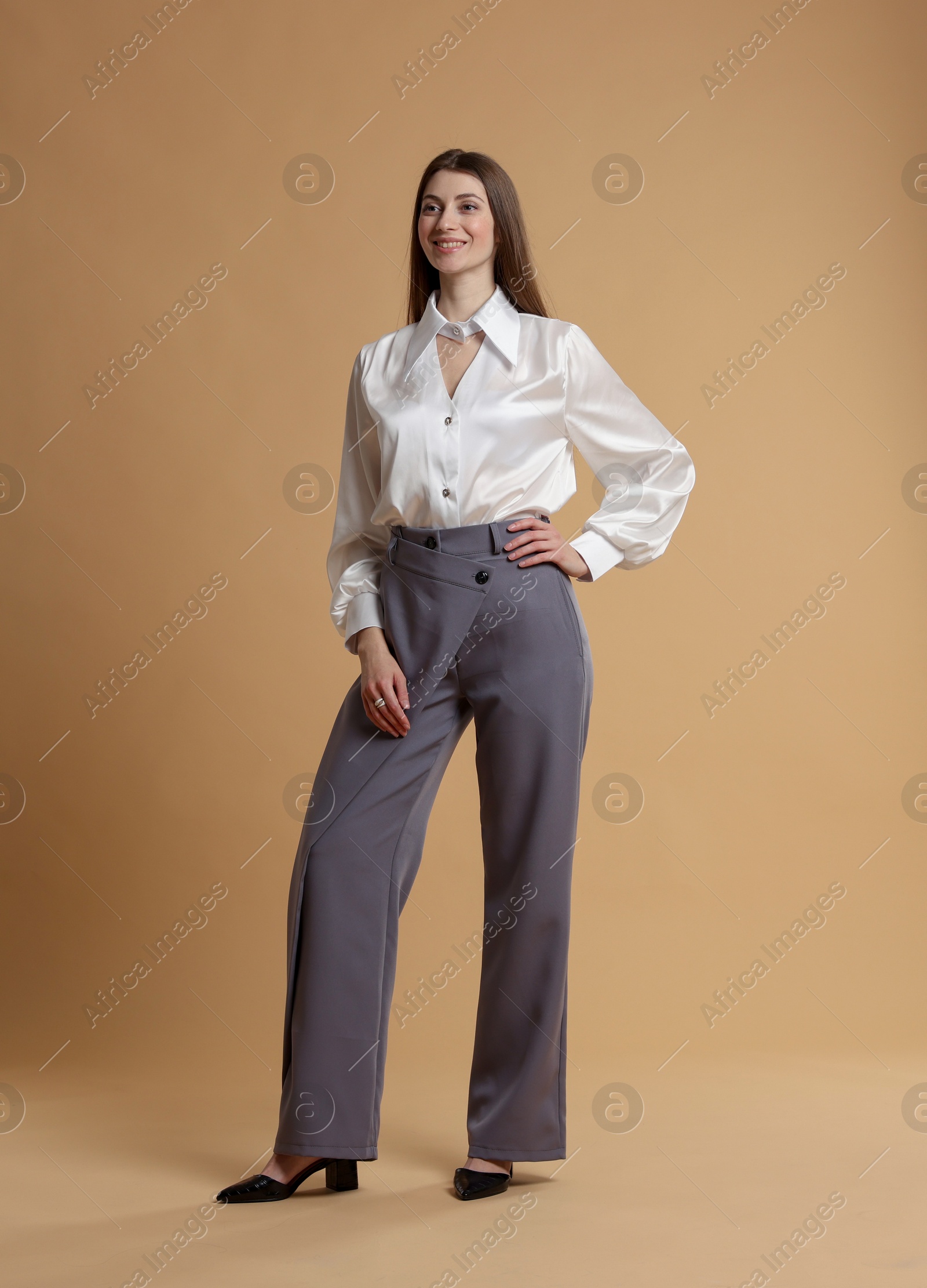 Photo of Beautiful woman in stylish outfit on beige background