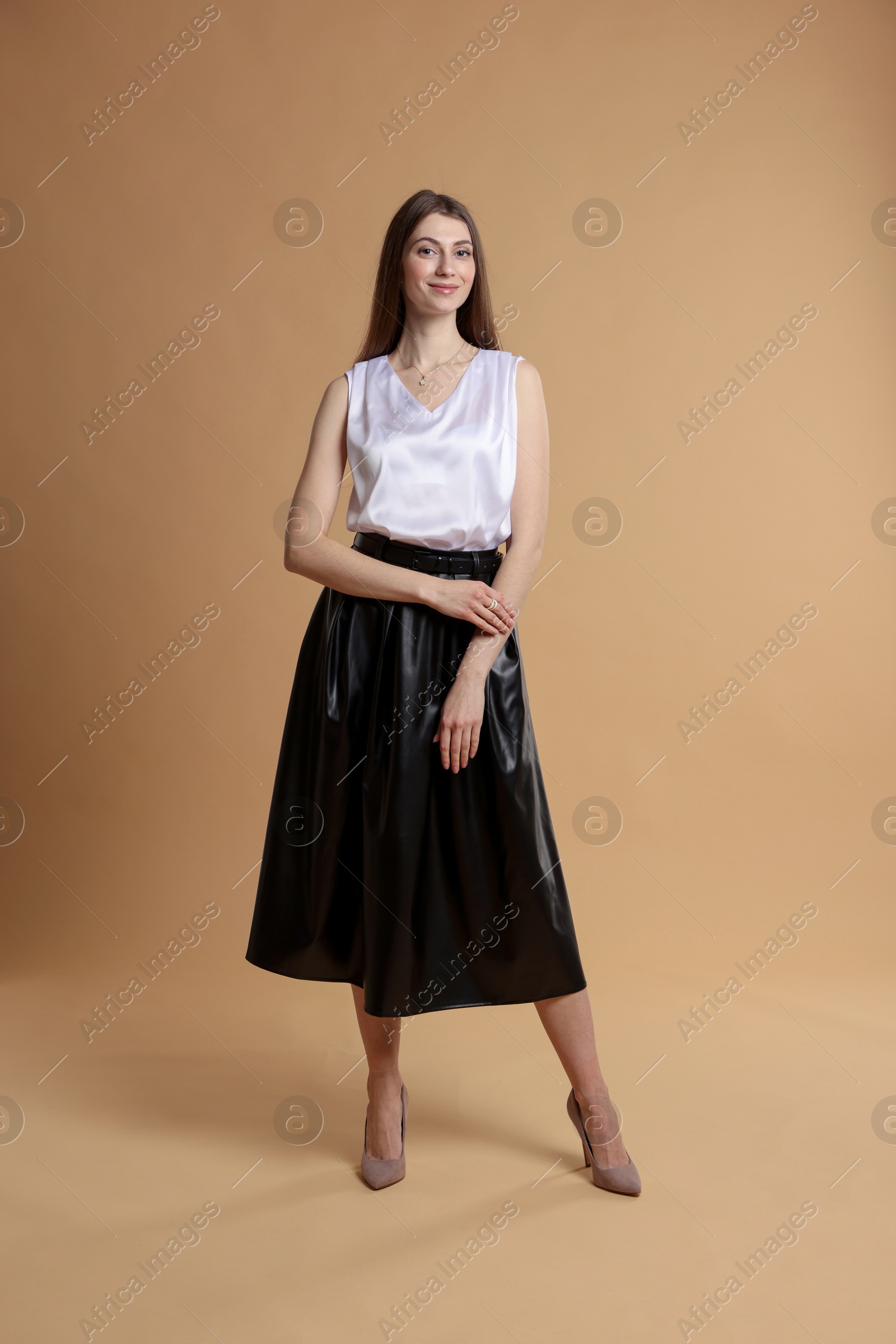 Photo of Beautiful woman in stylish outfit on beige background