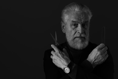 Photo of Bearded man with scissors and comb on dark background, space for text. Black and white effect