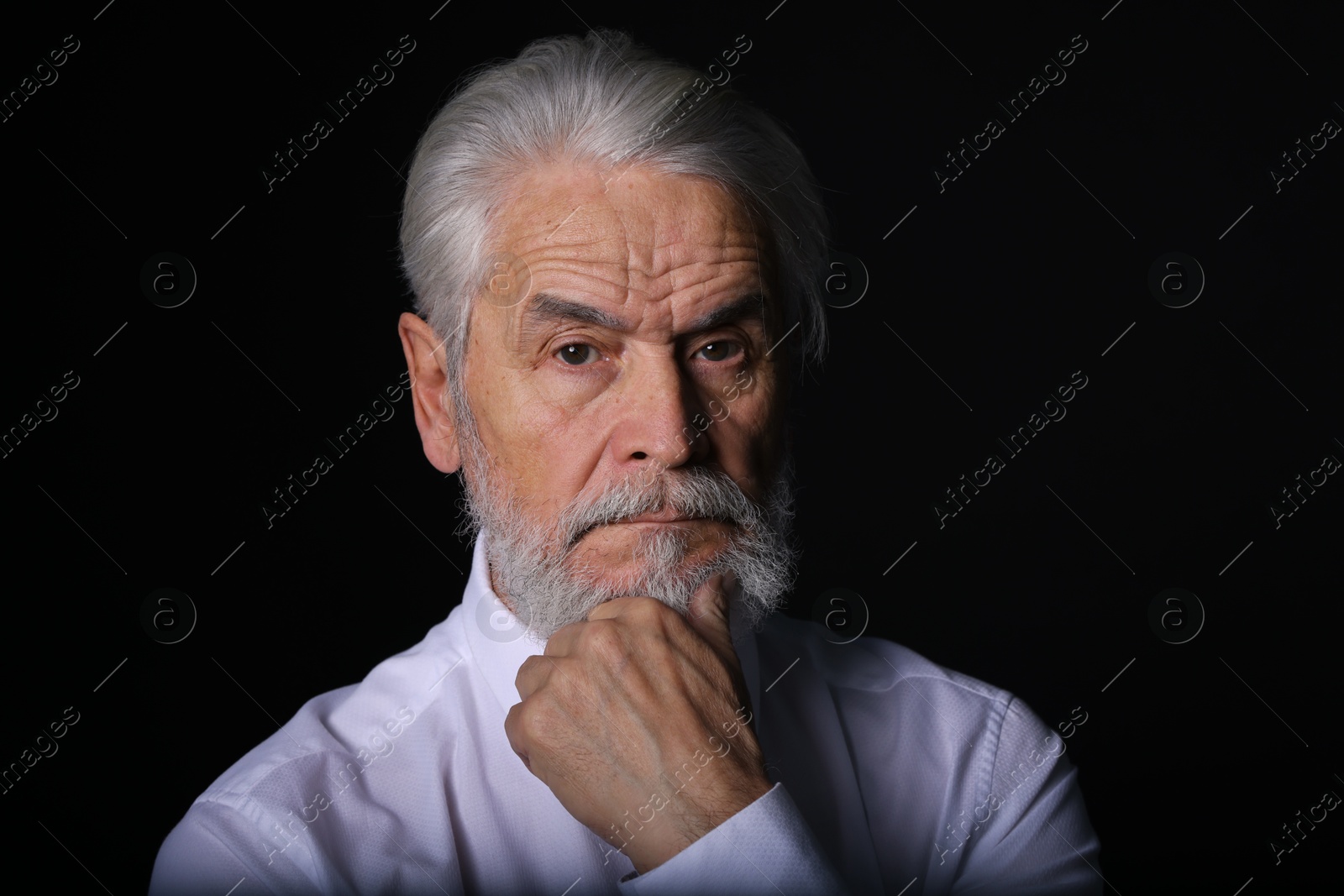 Photo of Portrait of handsome bearded man on black background