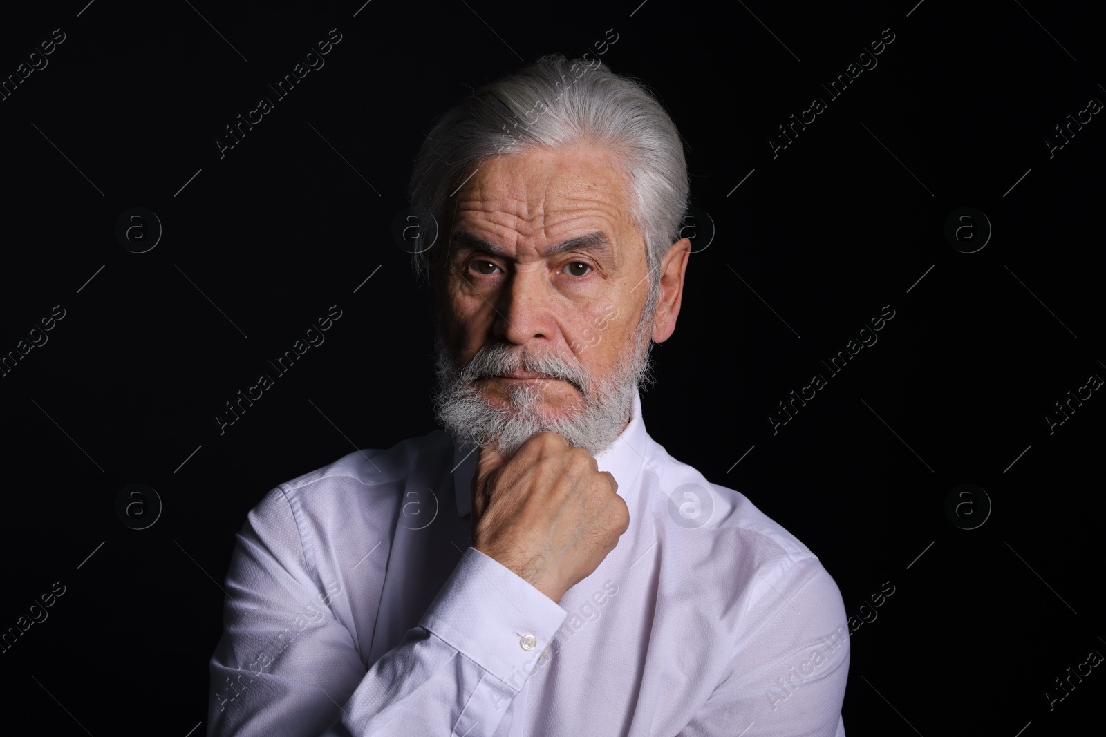 Photo of Portrait of handsome bearded man on black background