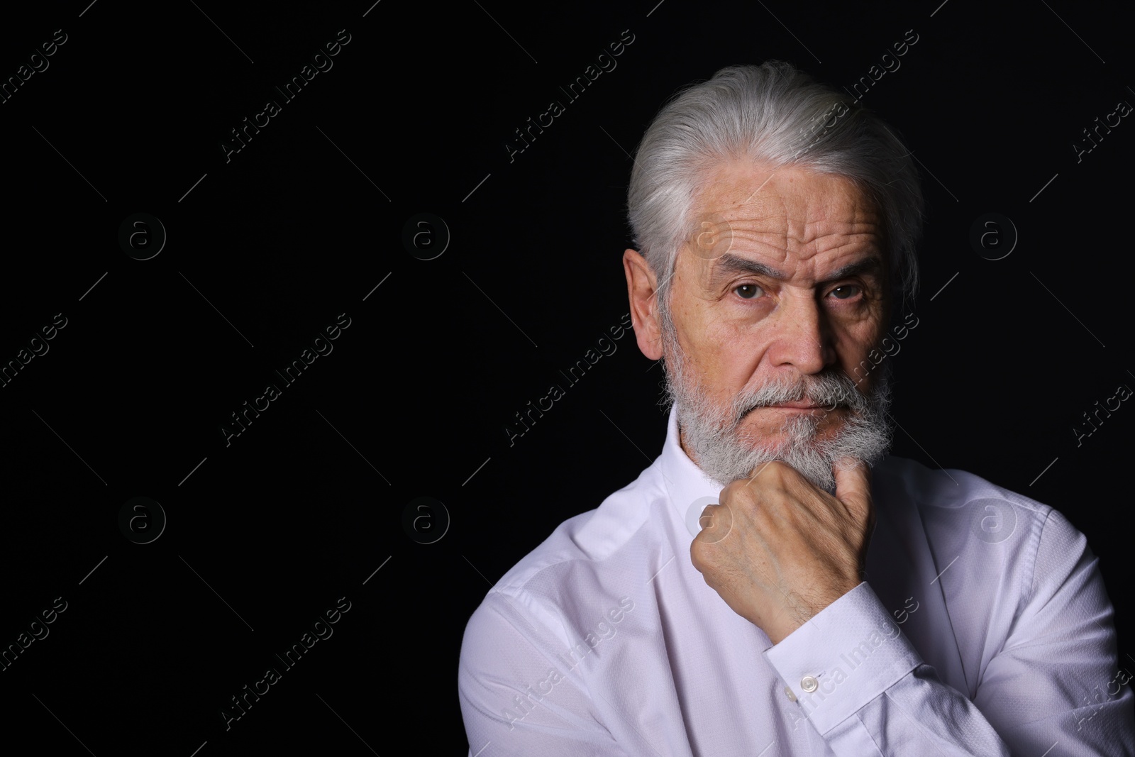 Photo of Portrait of handsome bearded man on black background, space for text