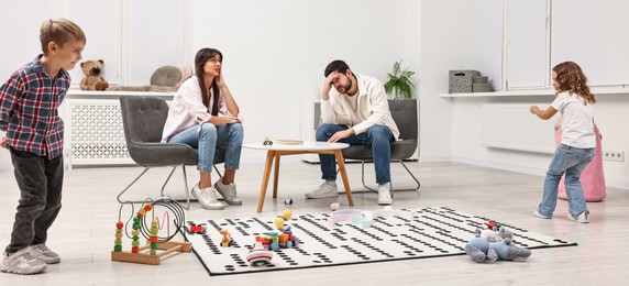 Photo of Hyperactive children playing and their overwhelmed parents at home