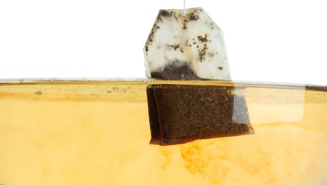 Putting tea bag into glass cup on white background, closeup