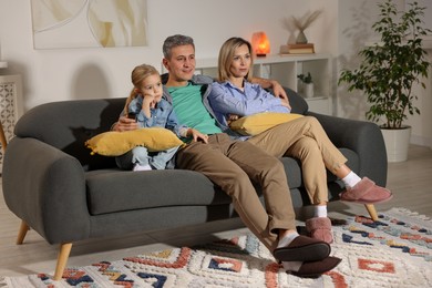 Photo of Family watching TV on sofa at home