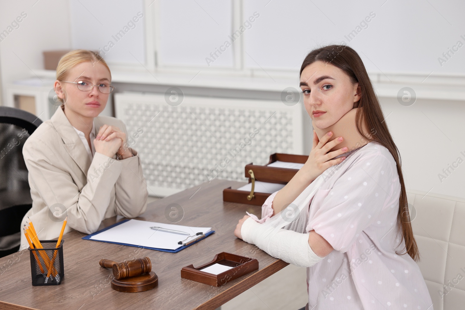 Photo of Injured woman and lawyer at table in office