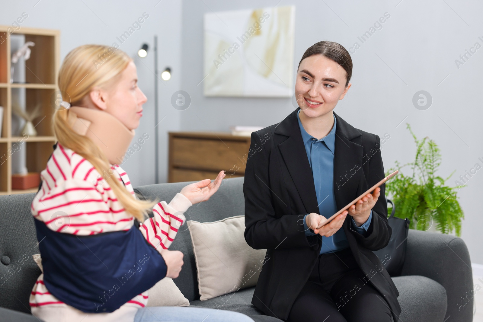 Photo of Injured woman having meeting with lawyer in office, selective focus