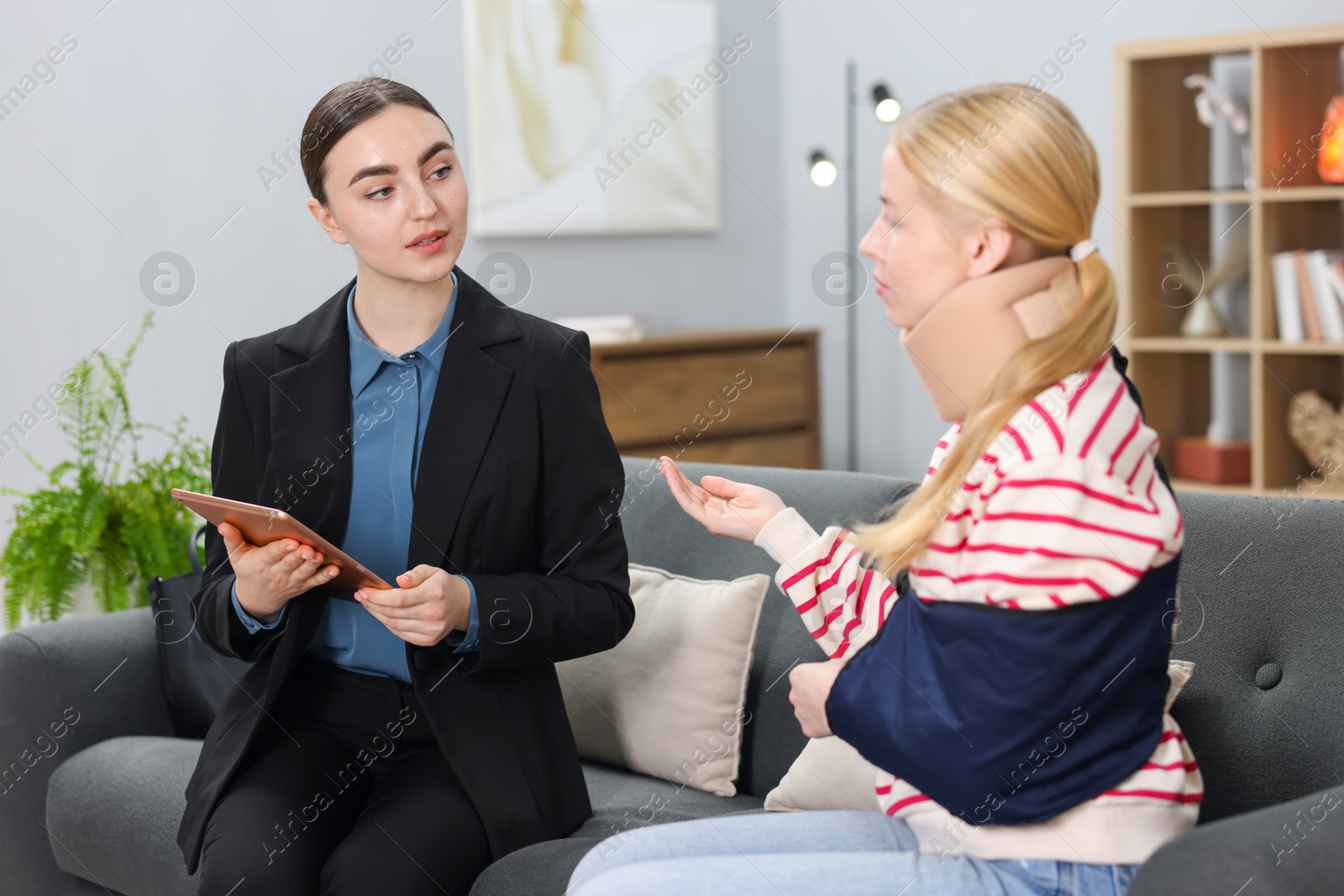 Photo of Injured woman having meeting with lawyer in office, selective focus