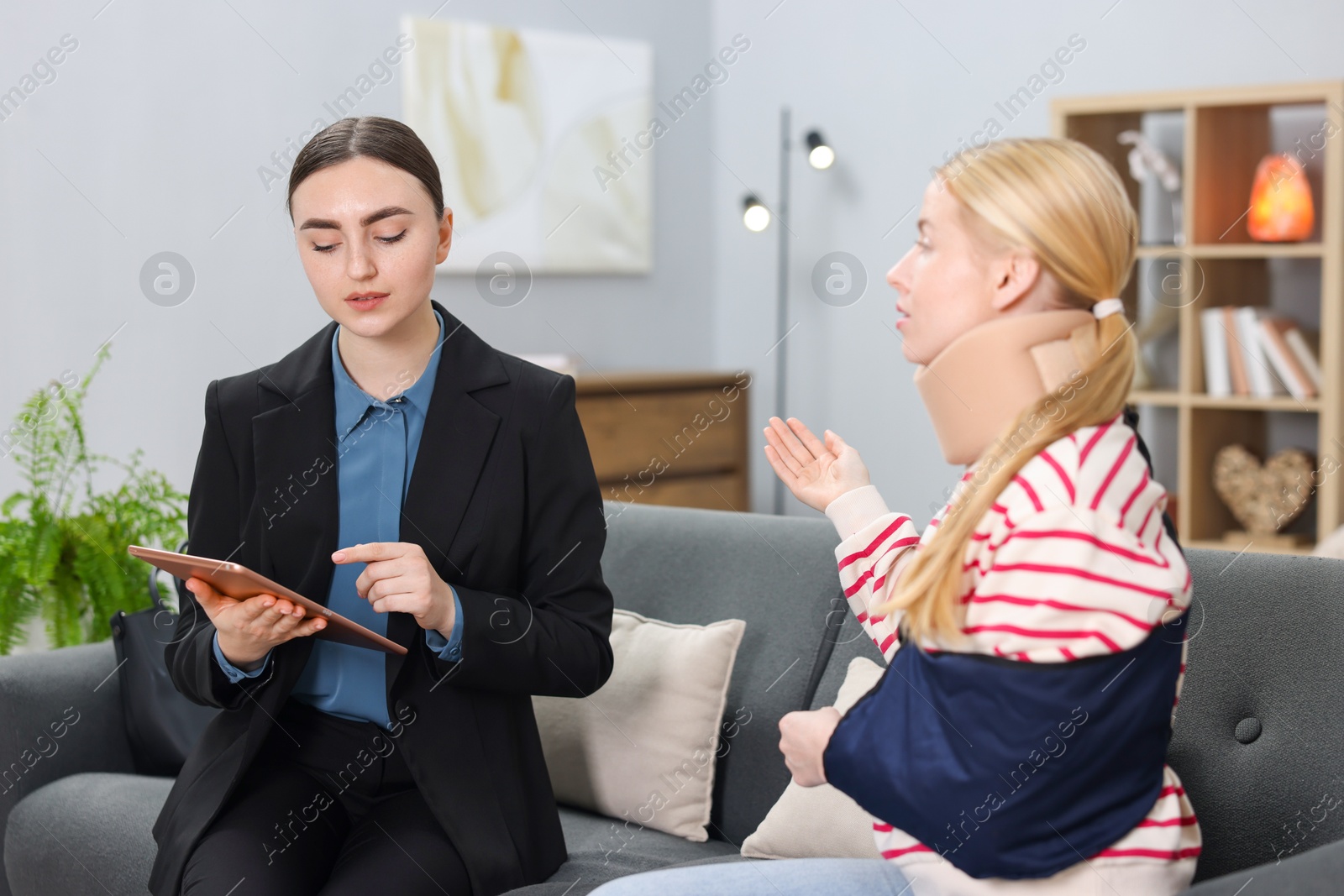 Photo of Injured woman having meeting with lawyer in office, selective focus