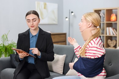 Injured woman having meeting with lawyer in office, selective focus