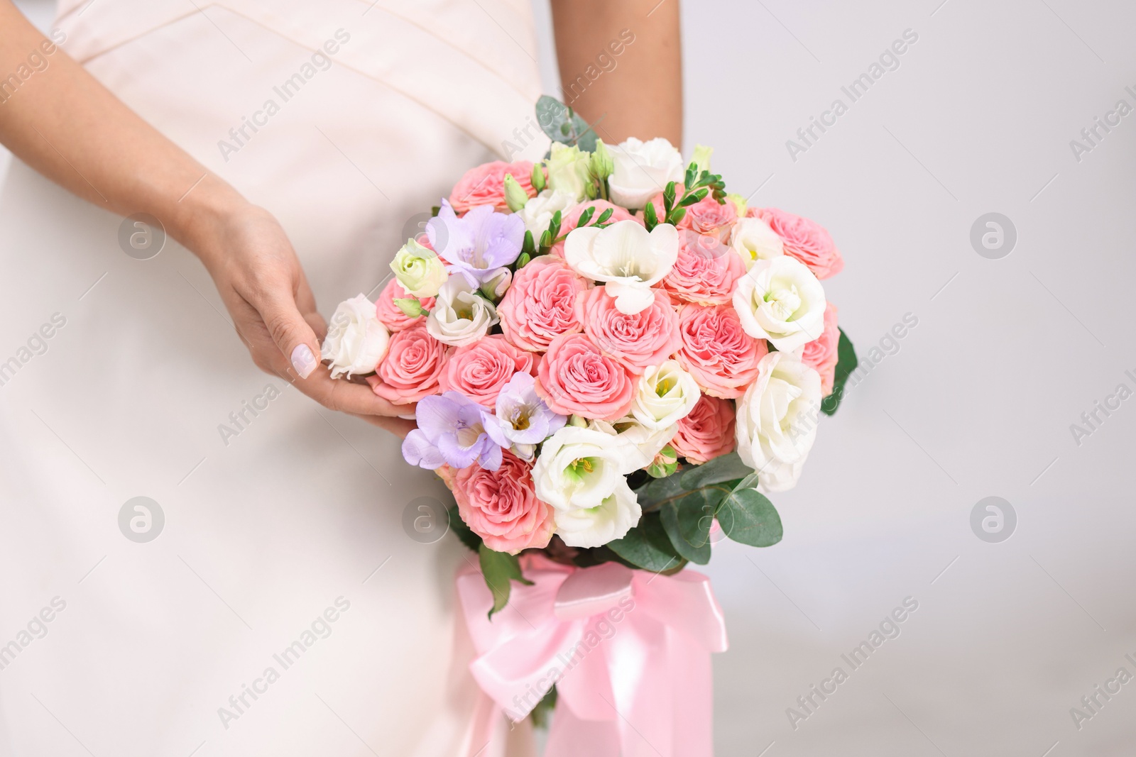 Photo of Bride with beautiful wedding bouquet on light background, closeup