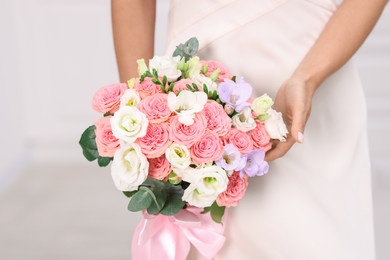 Photo of Bride with beautiful wedding bouquet on light background, closeup