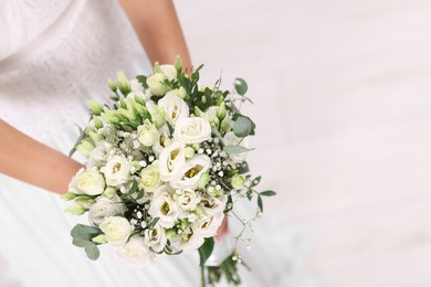 Photo of Bride with beautiful wedding bouquet on light background, closeup. Space for text