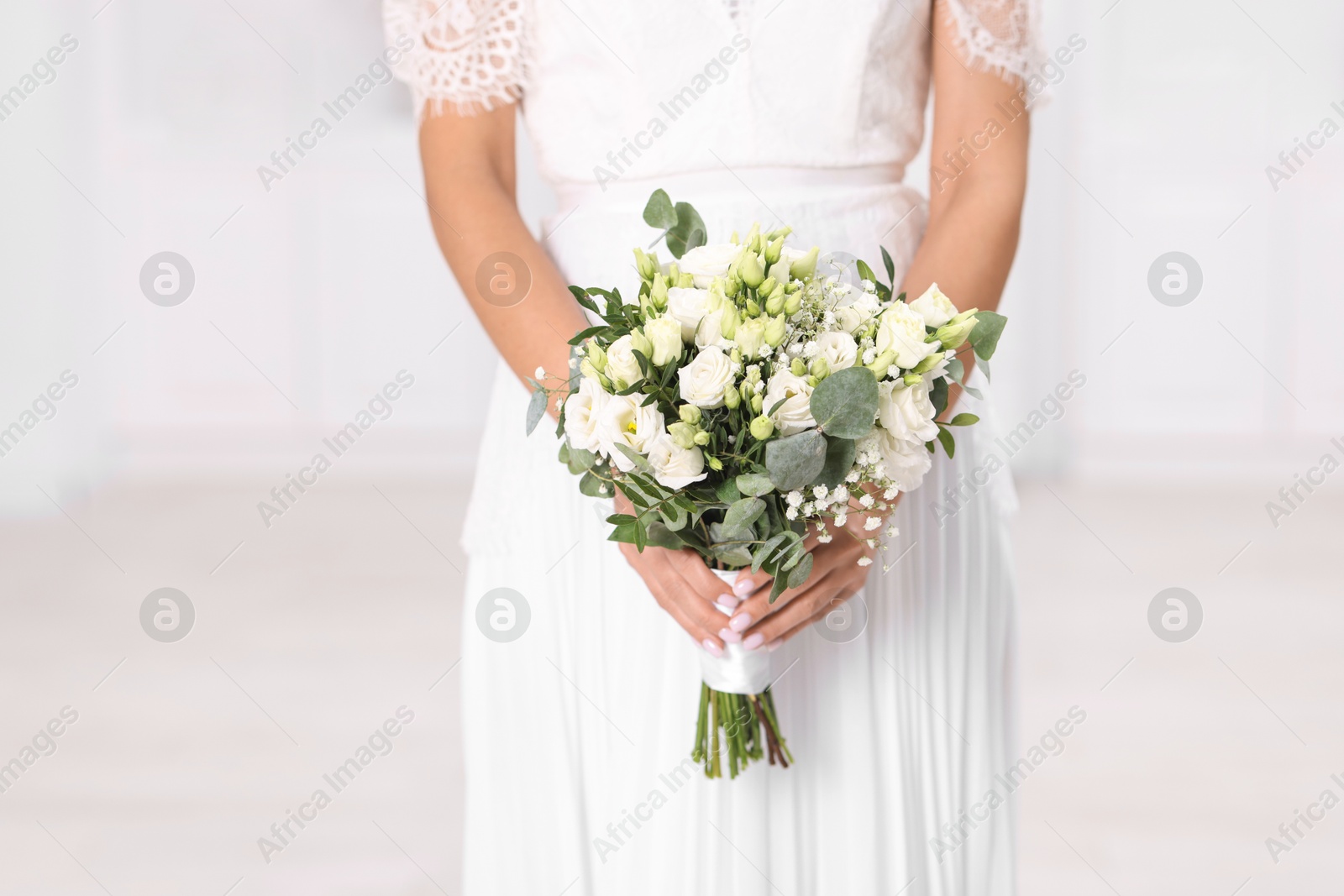 Photo of Bride with beautiful wedding bouquet on light background, closeup