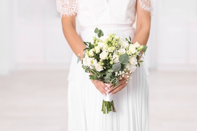 Photo of Bride with beautiful wedding bouquet on light background, closeup