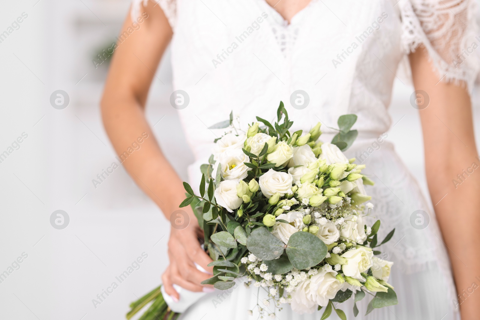 Photo of Bride with beautiful wedding bouquet on light background, closeup