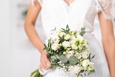 Photo of Bride with beautiful wedding bouquet on light background, closeup