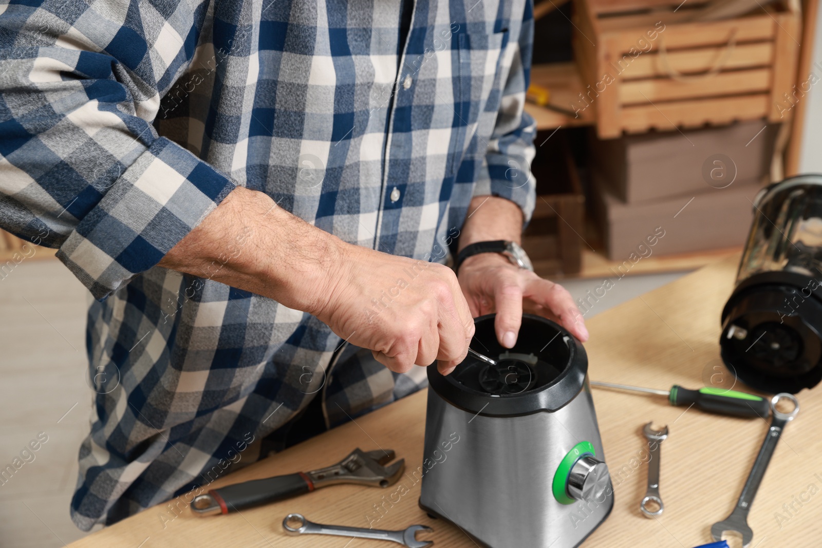 Photo of Relaxing hobby. Senior man repairing blender with wrench in workshop, closeup