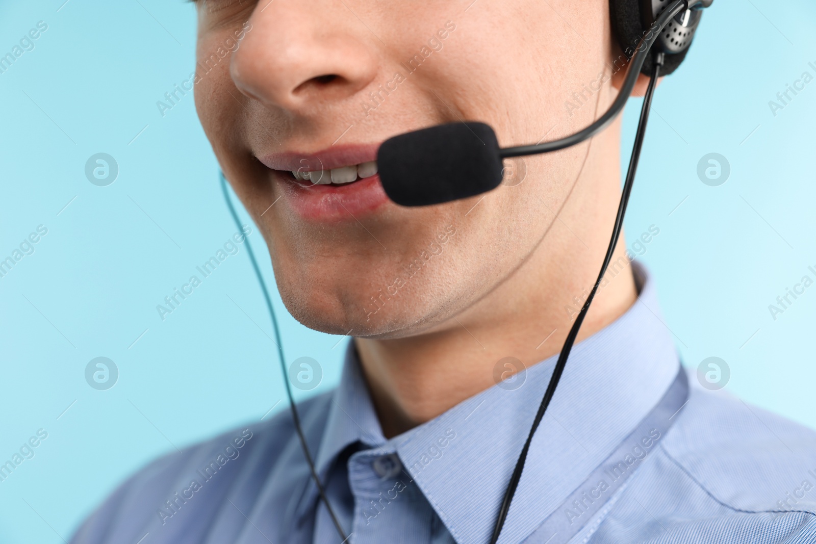 Photo of Technical support call center. Smiling operator on light blue background