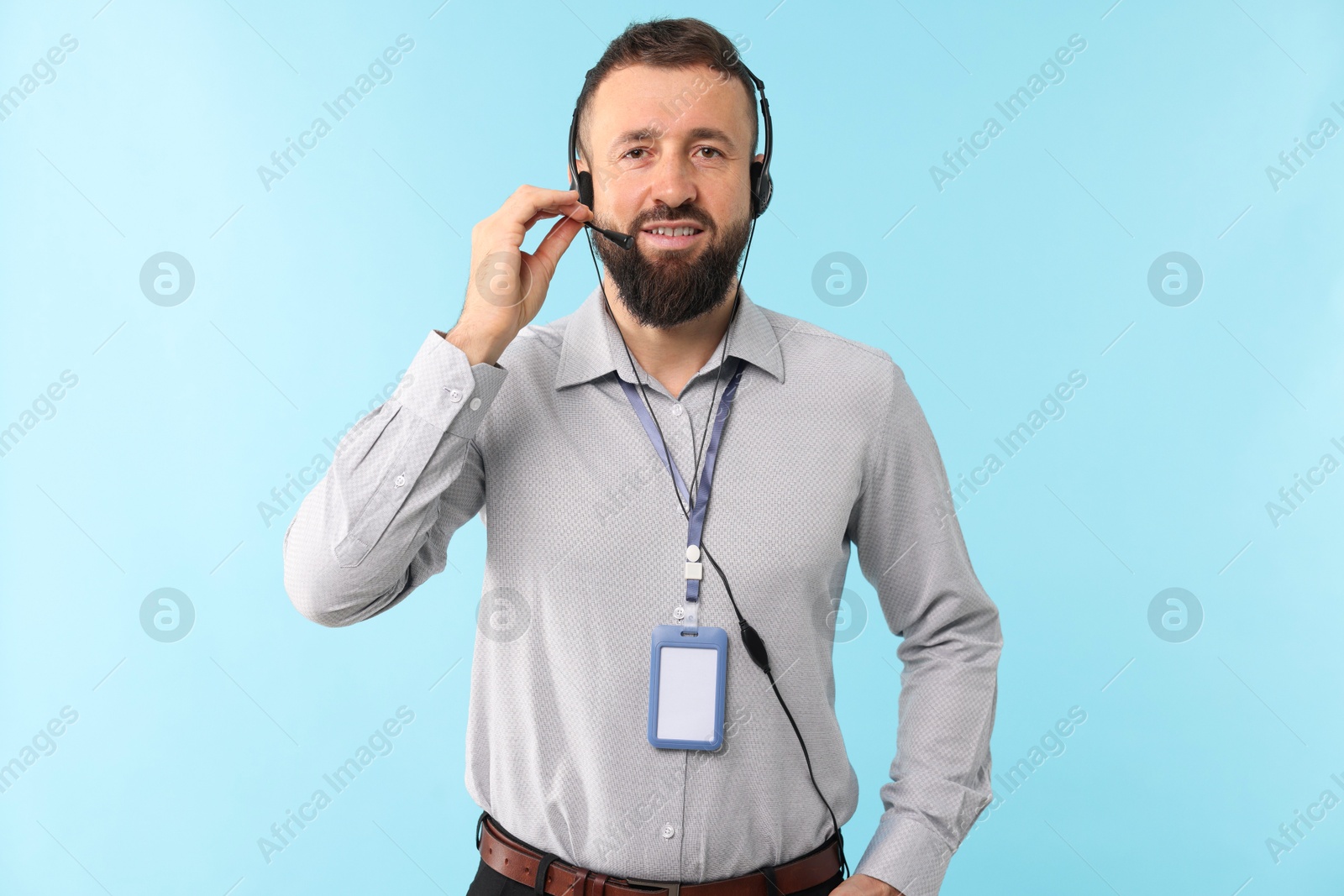 Photo of Technical support call center. Portrait of smiling operator on light blue background