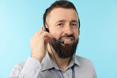 Photo of Technical support call center. Portrait of smiling operator on light blue background