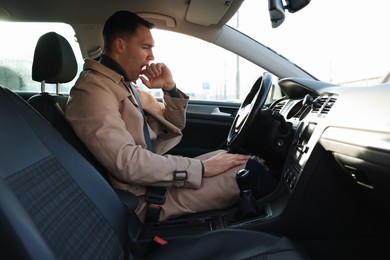 Photo of Sleepy driver yawning in his modern car