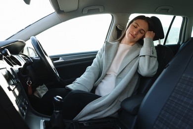 Photo of Tired driver sleeping in her modern car