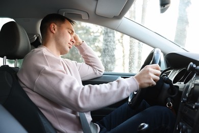 Photo of Tired driver sleeping in his modern car