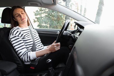 Photo of Tired driver sleeping in her modern car