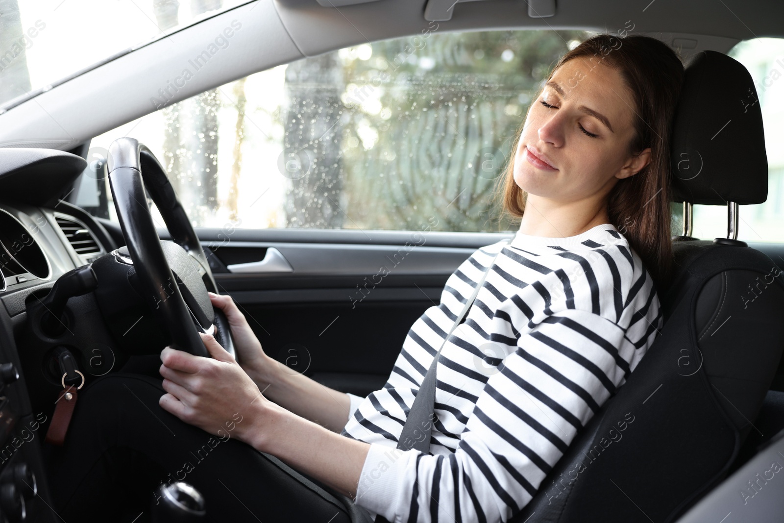 Photo of Tired driver sleeping in her modern car