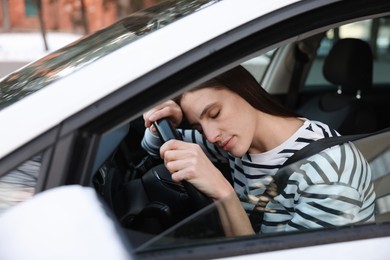 Photo of Tired driver sleeping on steering wheel in car, view from outside