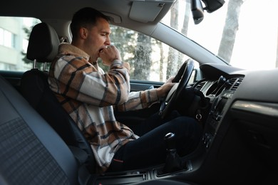 Photo of Sleepy driver yawning in his modern car