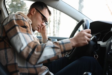 Photo of Tired driver sleeping in his modern car