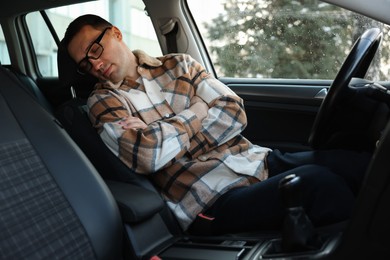 Photo of Tired driver sleeping in his modern car