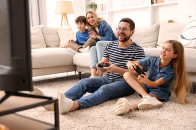 Photo of Happy family playing video games in living room