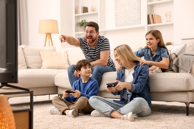 Photo of Happy family playing video games in living room