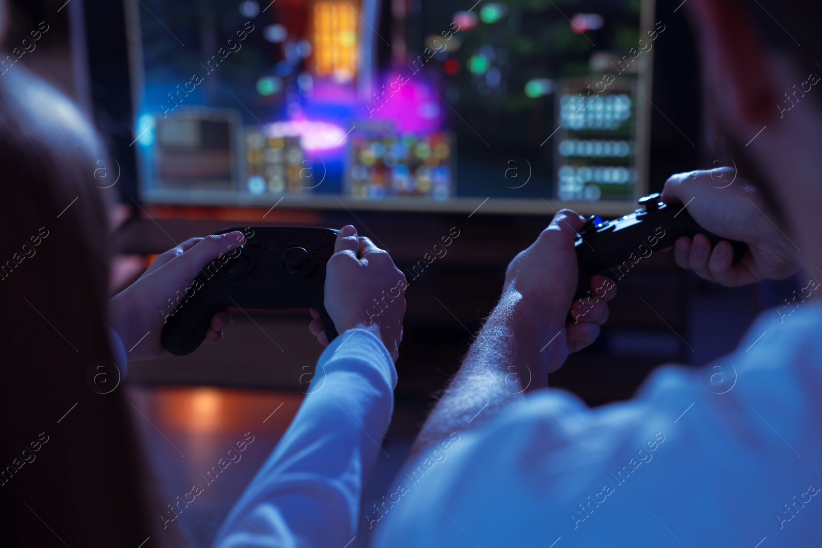 Photo of Father and his daughter playing video games at home, closeup