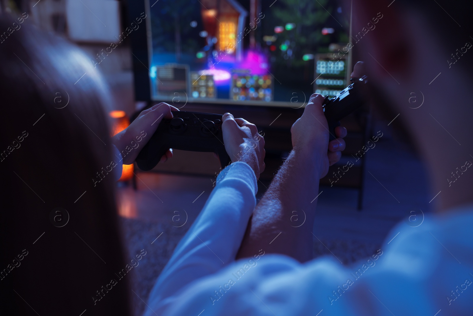 Photo of Father and his daughter playing video games at home, closeup