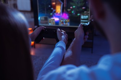 Photo of Father and his daughter playing video games at home, closeup