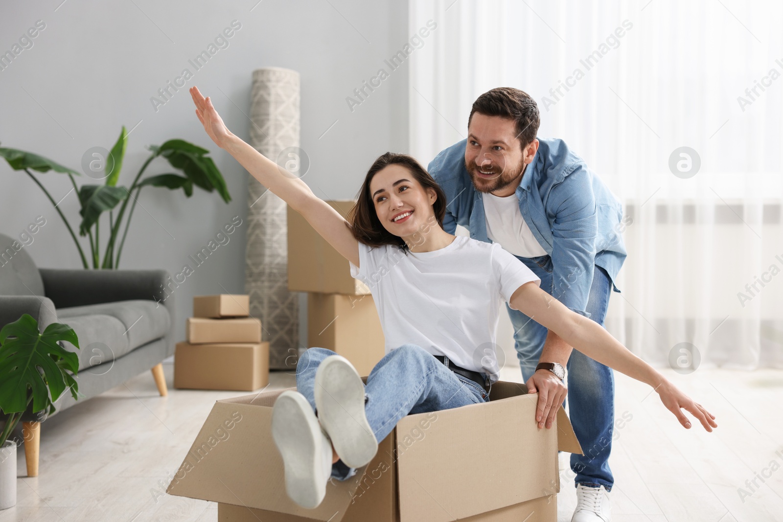 Photo of Moving day. Happy couple having fun in their new home