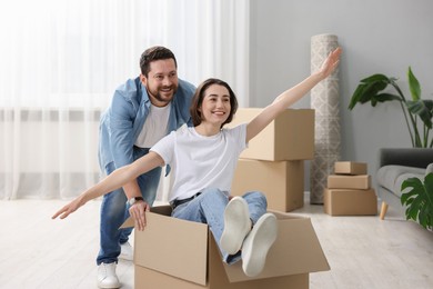 Photo of Moving day. Happy couple having fun in their new home