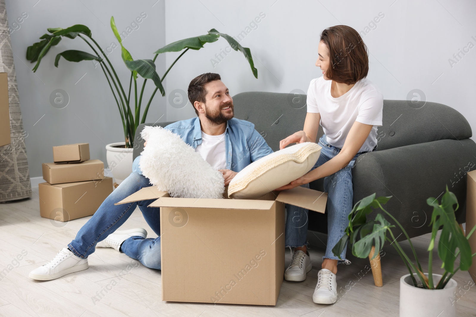 Photo of Moving day. Happy couple unpacking their belongings in new home