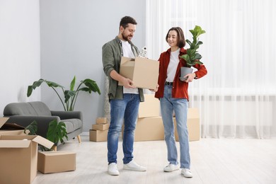 Moving day. Happy couple with their belongings in new home