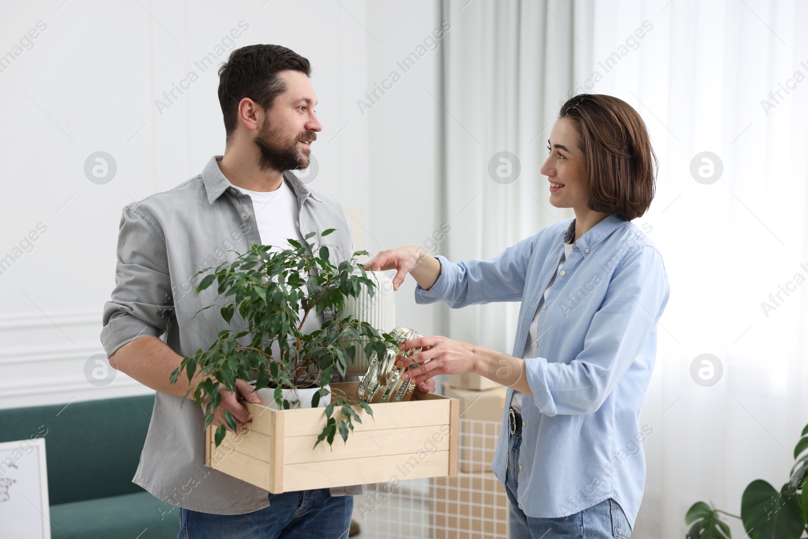 Photo of Moving day. Happy couple unpacking their belongings in new home