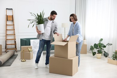 Photo of Moving day. Happy couple unpacking their belongings in new home