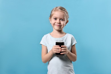 Photo of Girl with glass of refreshing soda drink on light blue background