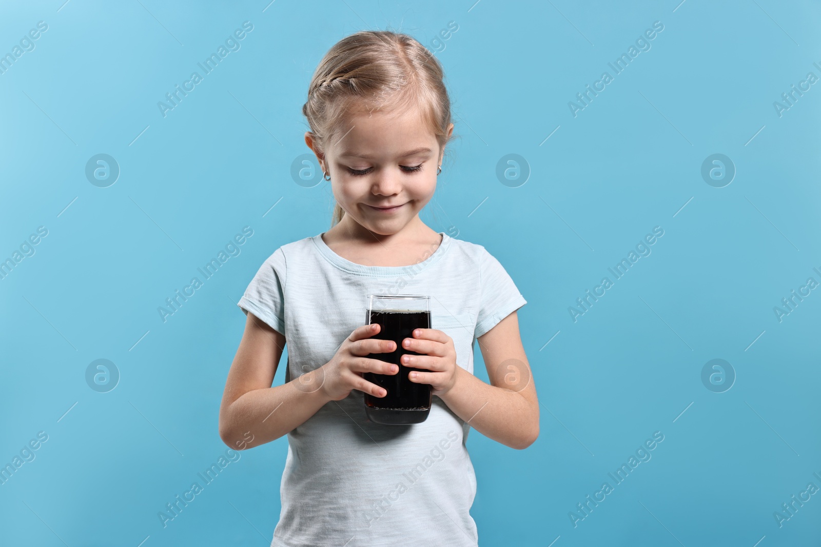 Photo of Girl with glass of refreshing soda drink on light blue background